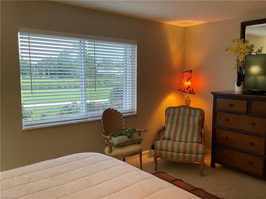 541 Teryl Road, Unit 1 Naples, FL 34112 - Photo 16 of 33 a bedroom with a bed and a chair