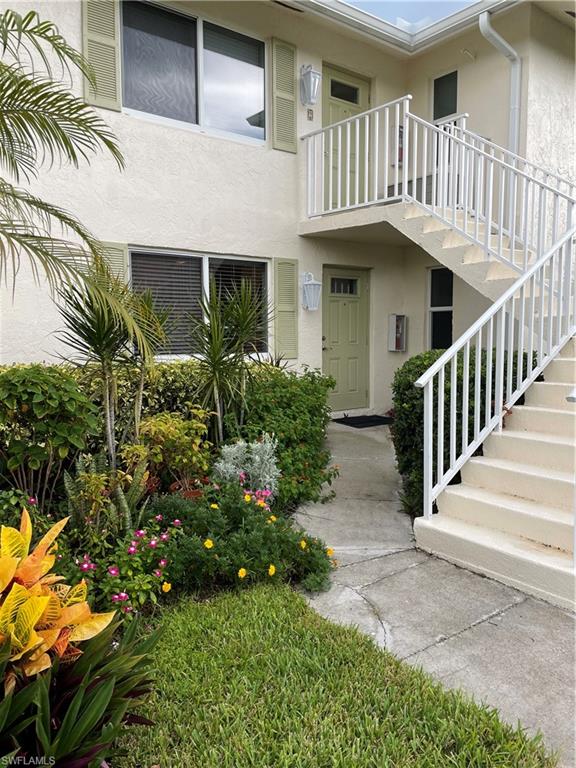 541 Teryl Road, Unit 1 Naples, FL 34112 - Photo 2 of 33 a view of a house with a small yard plants and wooden fence