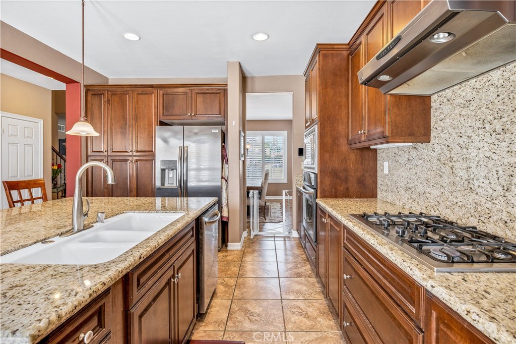 353 Caldera Street Perris, CA 92570 - Photo 20 of 53 a kitchen with stainless steel appliances granite countertop a sink stove and refrigerator