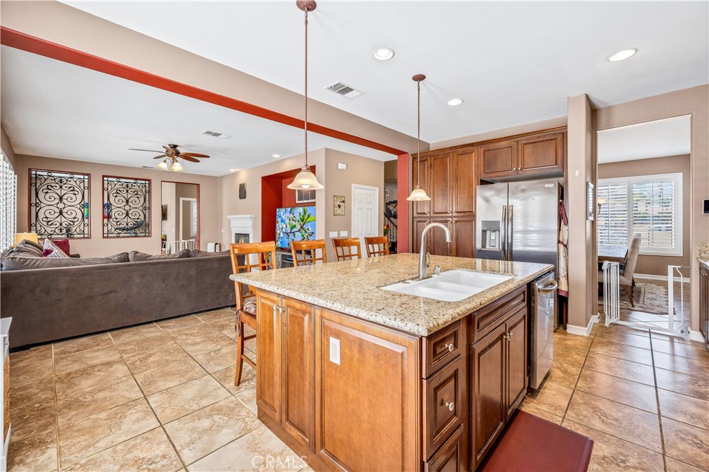 353 Caldera Street Perris, CA 92570 - Photo 21 of 53 a kitchen with stainless steel appliances granite countertop a sink and a refrigerator