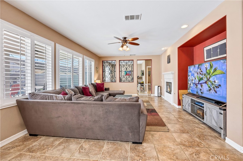 353 Caldera Street Perris, CA 92570 - Photo 25 of 53 a living room with furniture a flat screen tv and a large window