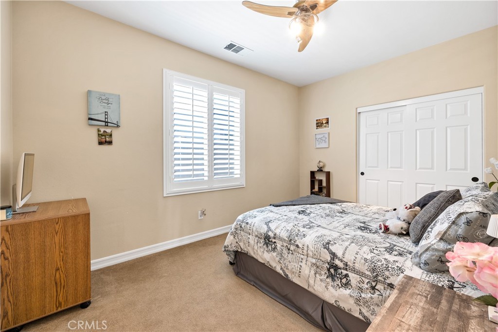 353 Caldera Street Perris, CA 92570 - Photo 29 of 53 a bedroom with a bed and a chandelier