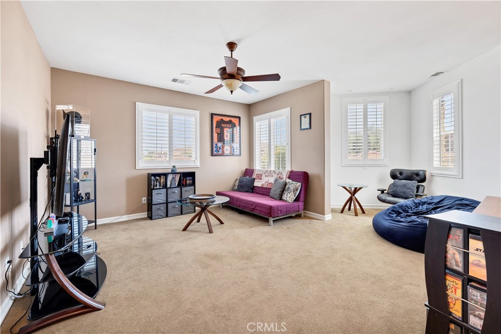 353 Caldera Street Perris, CA 92570 - Photo 32 of 53 a living room with furniture gym equipment and a flat screen tv