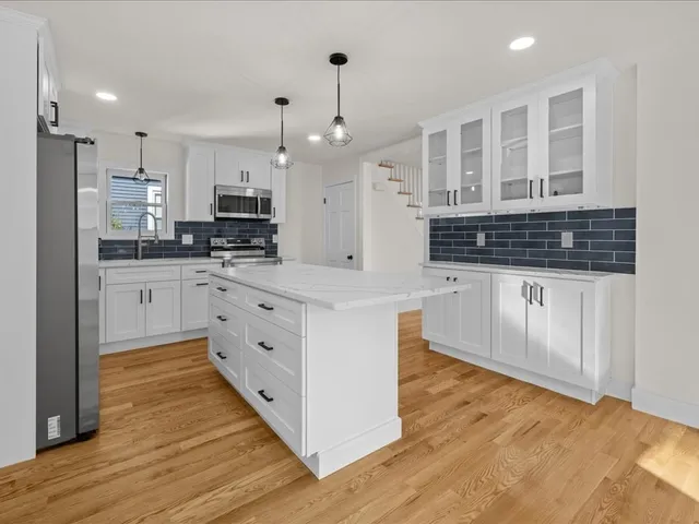 a kitchen with stainless steel appliances kitchen island granite countertop a stove and a sink