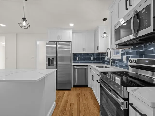 a kitchen with stainless steel appliances a stove a sink and a refrigerator
