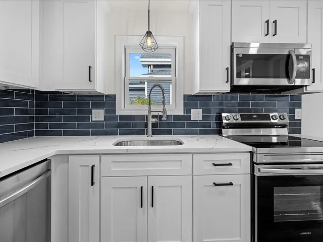 a kitchen with stainless steel appliances granite countertop a sink and a microwave