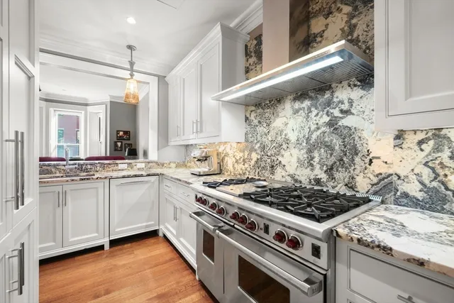 a spacious kitchen with stainless steel appliances granite countertop a stove and a sink