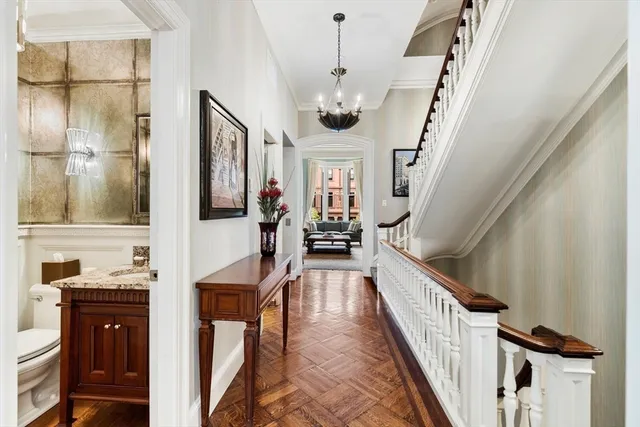 a view of a hallway with wooden floor and staircase