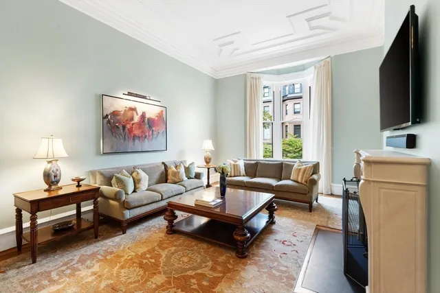 a living room with furniture a rug and a flat screen tv