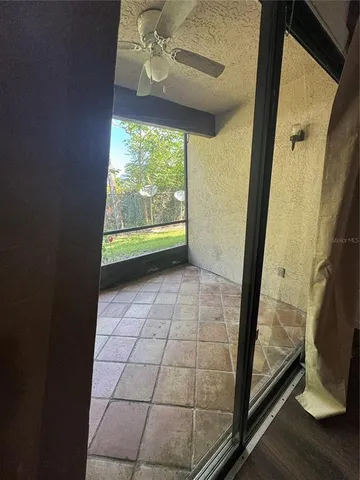 a view of an empty room with wooden floor and door