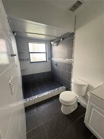 a bathroom with a toilet and a shower