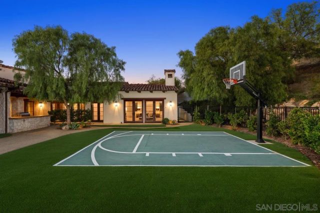 a bathroom with a granite countertop sink a mirror and shower