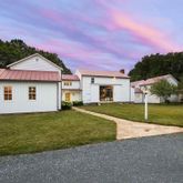 a view of a house with a yard and large tree