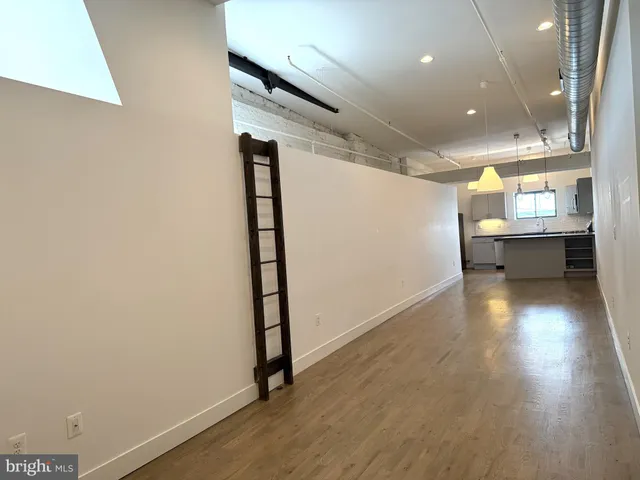 a view of a room with wooden floor and furniture