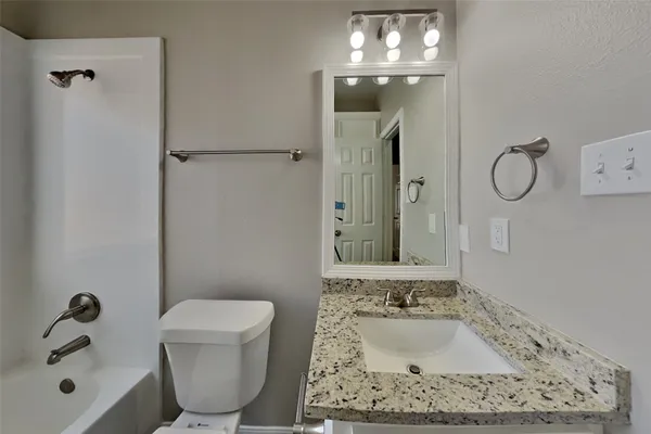 a bathroom with a tub a sink and a mirror