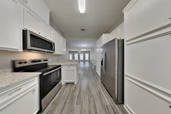 a kitchen with stainless steel appliances a stove microwave and a refrigerator