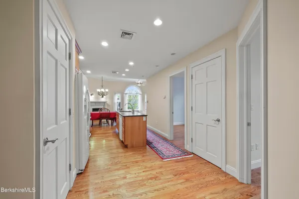 a living room with stainless steel appliances furniture a rug and a kitchen view