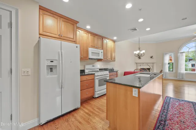 a kitchen with granite countertop sink cabinets and wooden floor