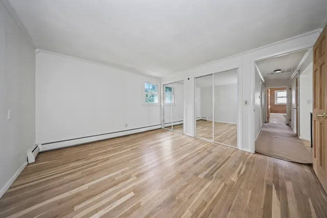 a view of empty room with wooden floor