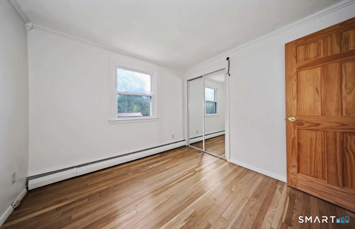 1114 Fienemann Road Farmington, CT 06032 - Photo 14 of 28 a view of an empty room with wooden floor and a window
