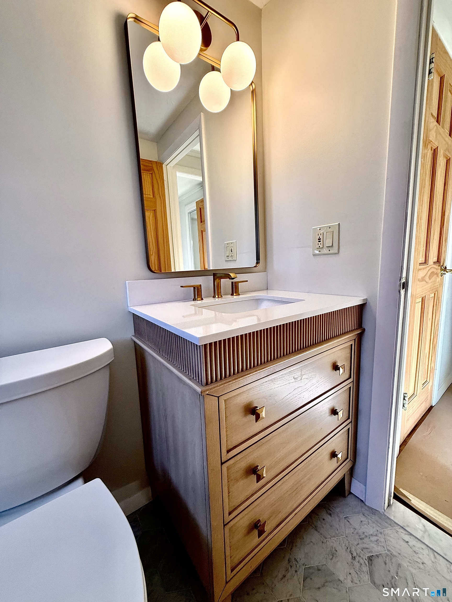 1114 Fienemann Road Farmington, CT 06032 - Photo 23 of 28 a bathroom with a sink a mirror and a toilet