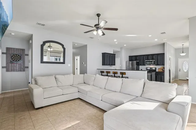 a living room with furniture and kitchen view