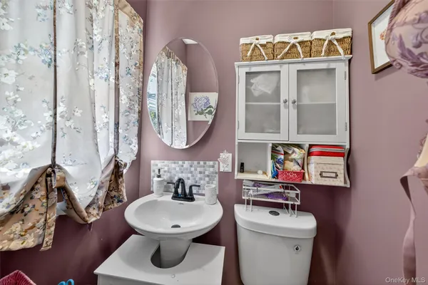 a bathroom with a toilet a sink and a mirror