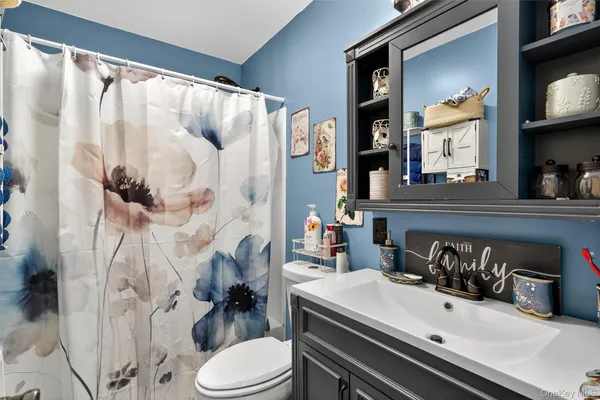 a bathroom with a sink vanity mirror and toilet