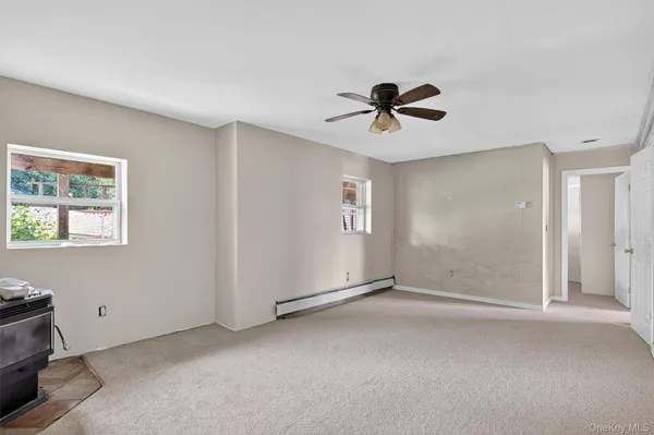 a view of a livingroom with a ceiling fan and window