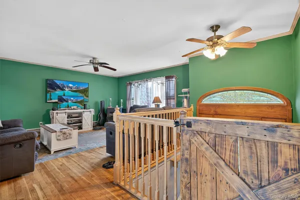 a view of a livingroom with furniture hardwood floor and a ceiling fan