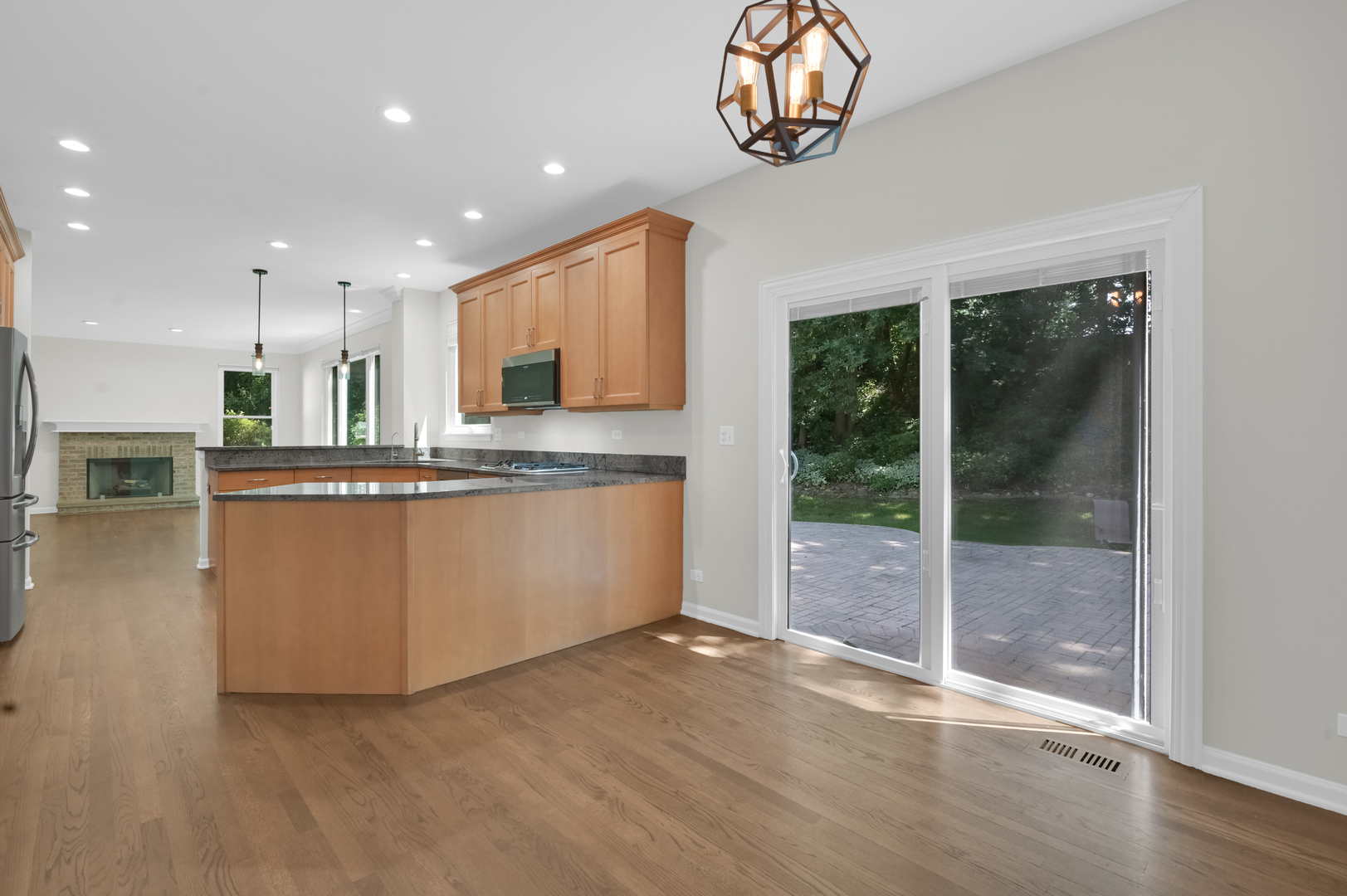 502 Windsor Circle Fox River Grove, IL 60021 - Photo 8 of 41 a kitchen with kitchen island granite countertop a stove a sink a refrigerator and a dining table with wooden floor