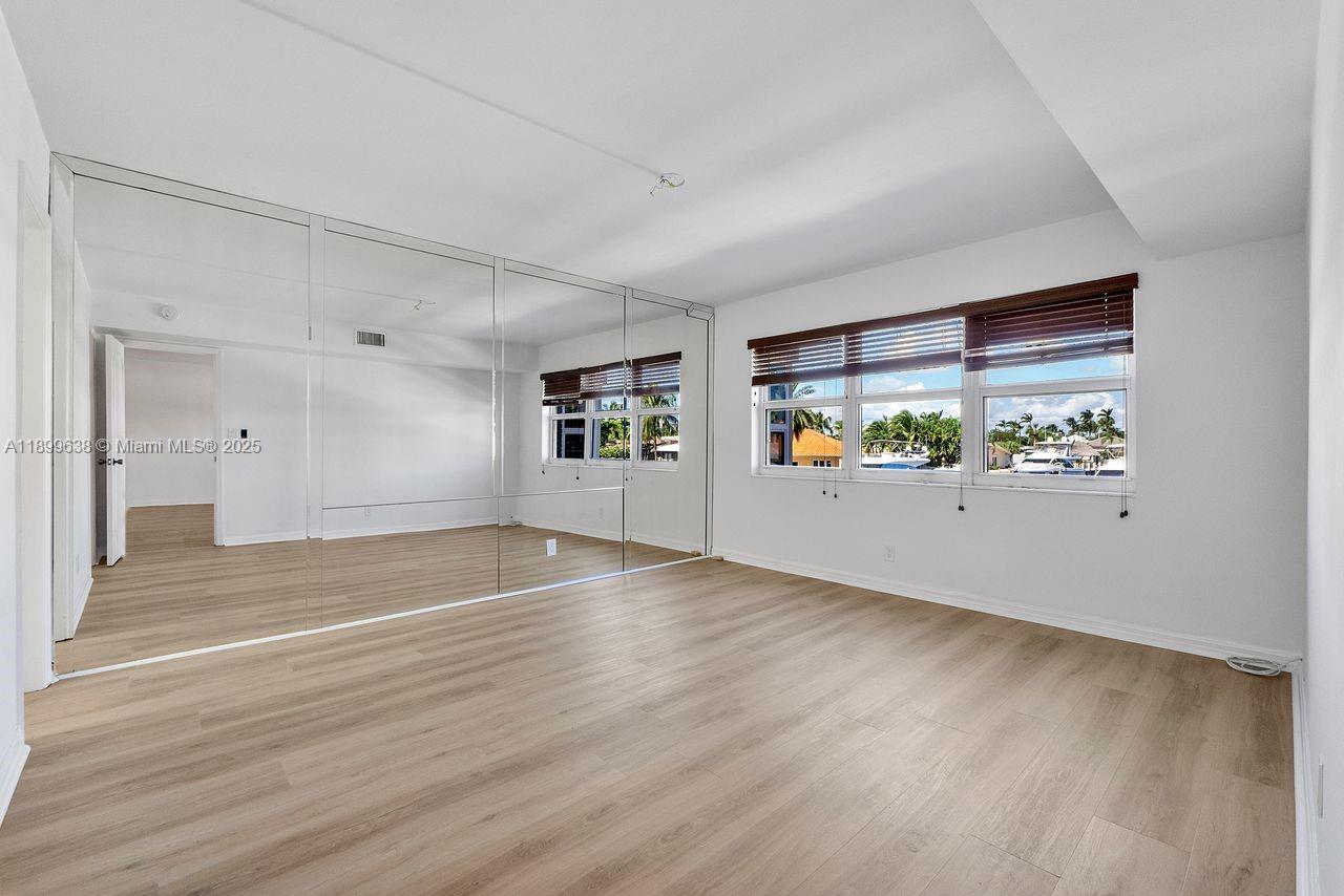 3111 Northeast 51st Street, Unit 202C Fort Lauderdale, FL 33308 - Photo 26 of 46 wooden floor in an empty room with a window