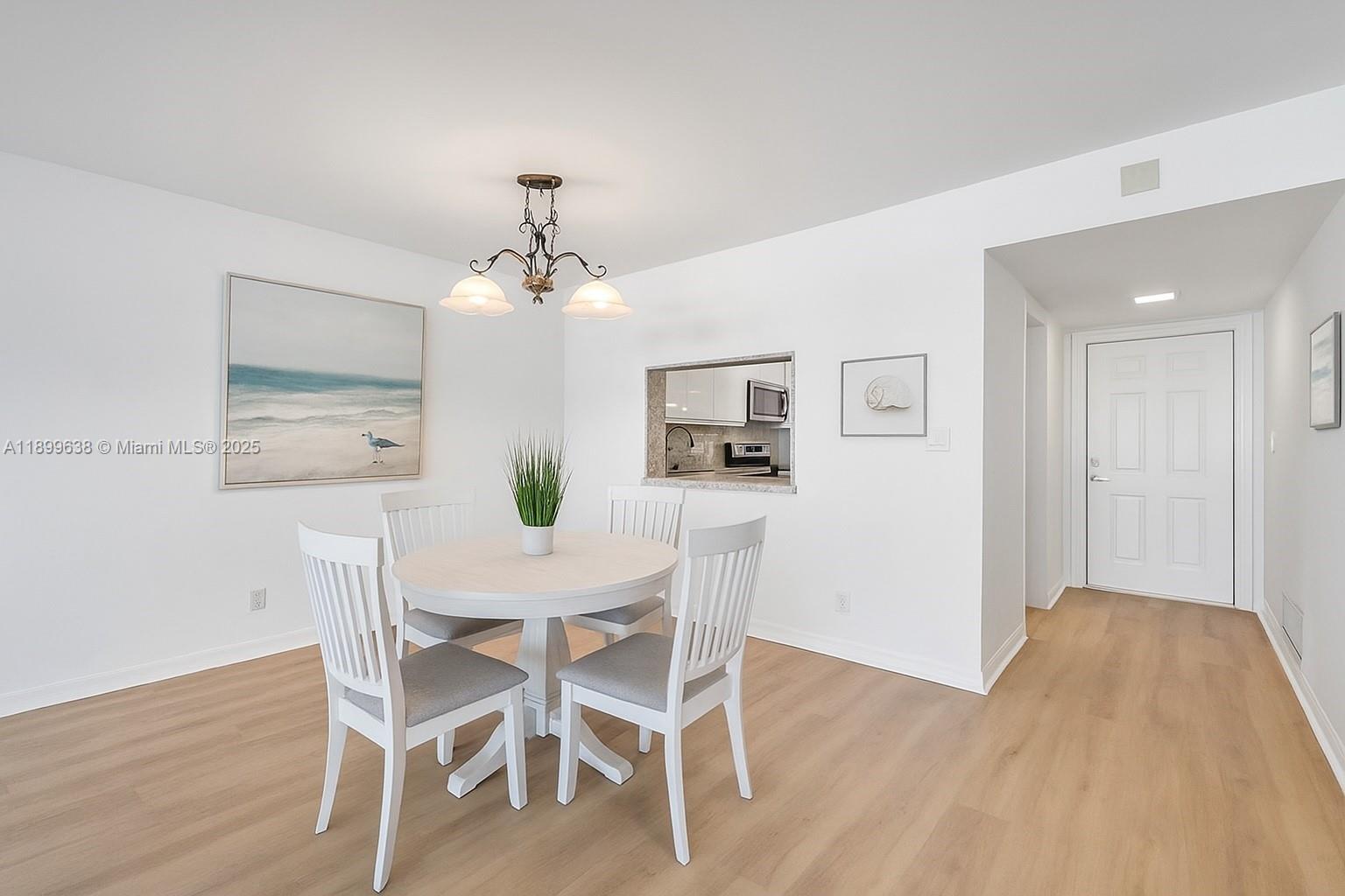 3111 Northeast 51st Street, Unit 202C Fort Lauderdale, FL 33308 - Photo 3 of 46 a view of a dining room with furniture and wooden floor