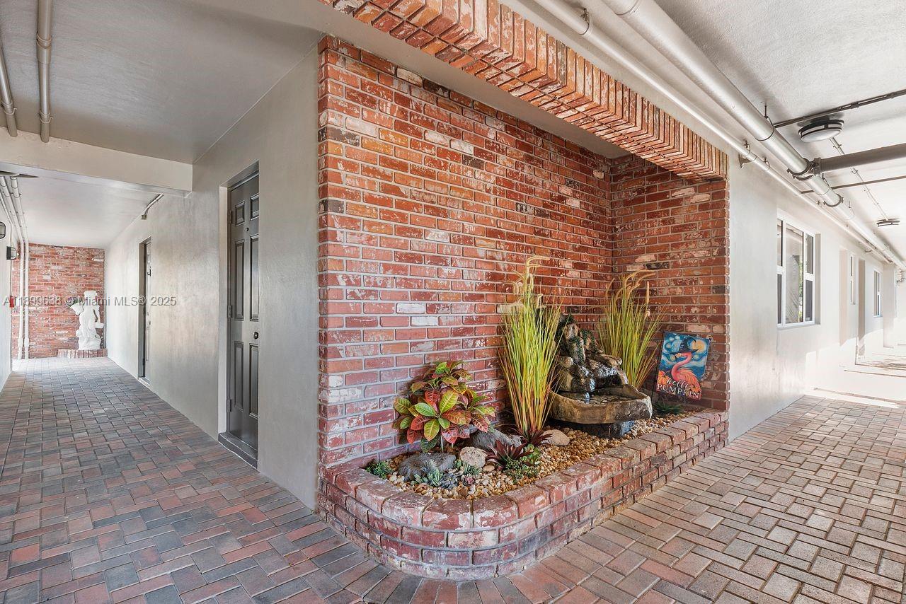 3111 Northeast 51st Street, Unit 202C Fort Lauderdale, FL 33308 - Photo 35 of 46 a view of a hallway with flower pots