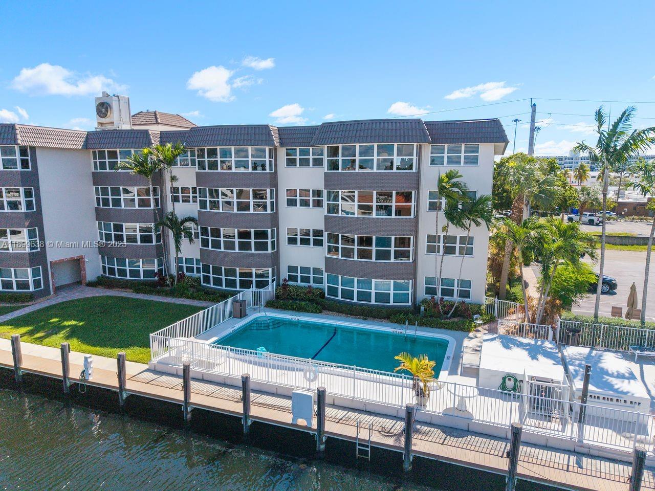 3111 Northeast 51st Street, Unit 202C Fort Lauderdale, FL 33308 - Photo 43 of 46 a view of a swimming pool with a lounge chairs and a yard