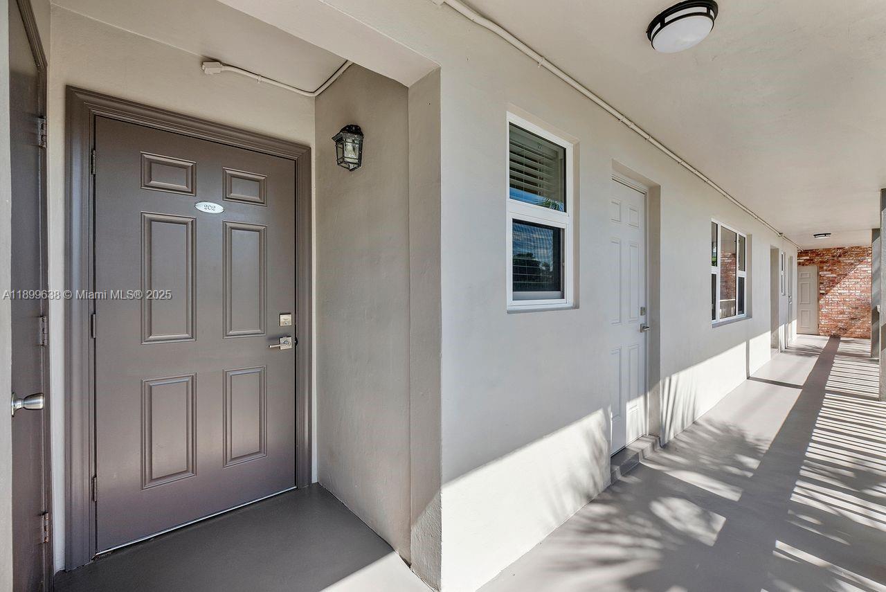 3111 Northeast 51st Street, Unit 202C Fort Lauderdale, FL 33308 - Photo 7 of 46 a view of a hallway with windows and stairs