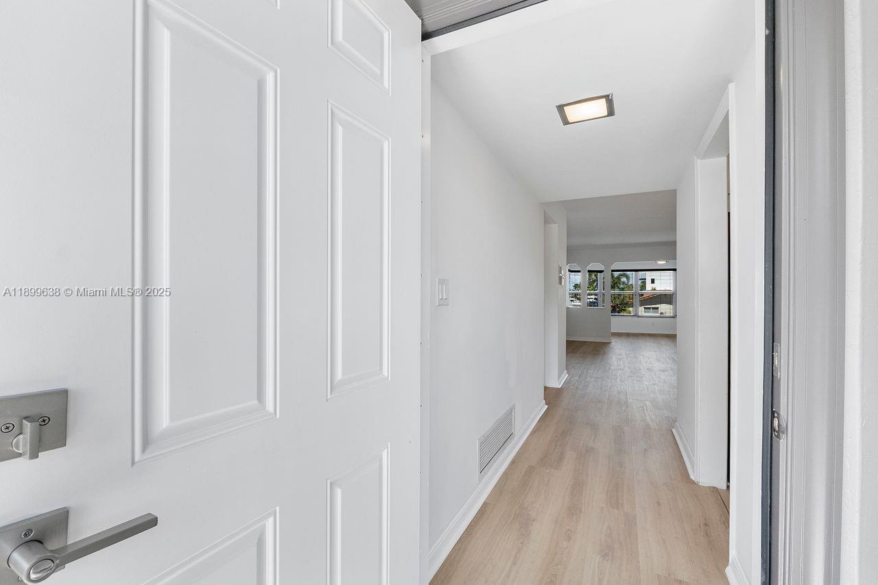 3111 Northeast 51st Street, Unit 202C Fort Lauderdale, FL 33308 - Photo 8 of 46 a view of a hallway with closet and a couch