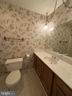 a bathroom with a granite countertop toilet and a sink