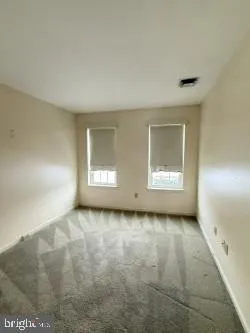 a view of a room with wooden floor and windows