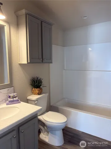 a kitchen with stainless steel appliances granite countertop a sink a stove a microwave and wooden cabinets