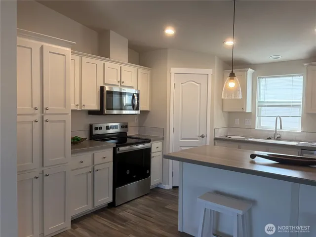 a kitchen with refrigerator a sink and chairs