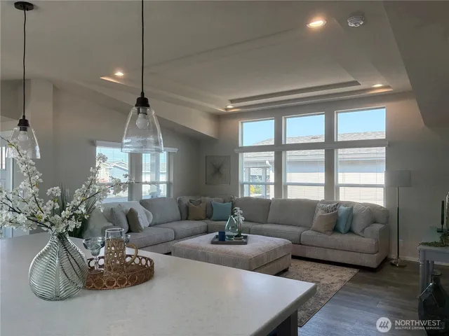 a living room with furniture a chandelier and a large window