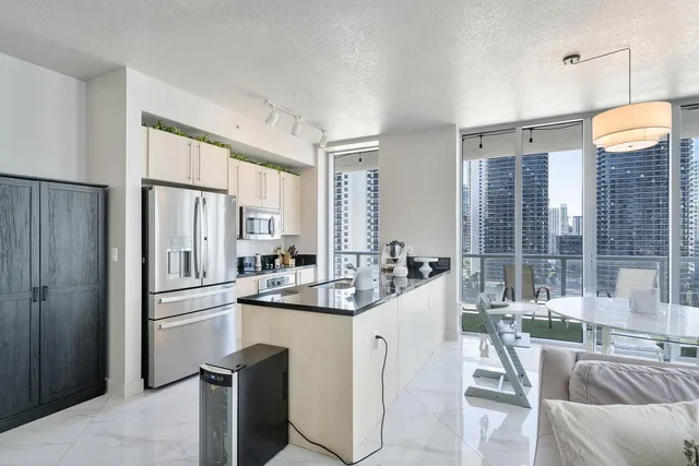 a kitchen with stainless steel appliances granite countertop a sink and a refrigerator