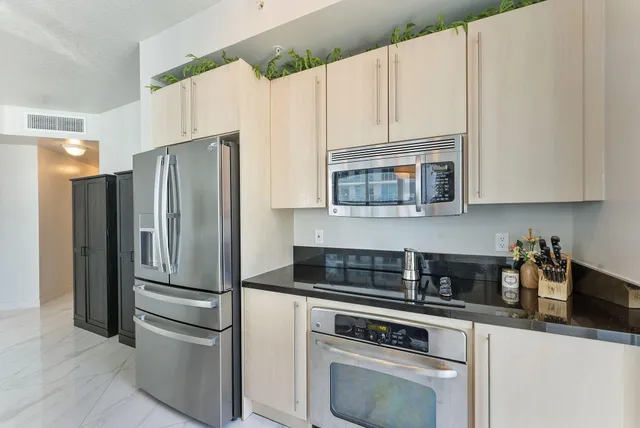 a kitchen with cabinets stainless steel appliances and a counter space
