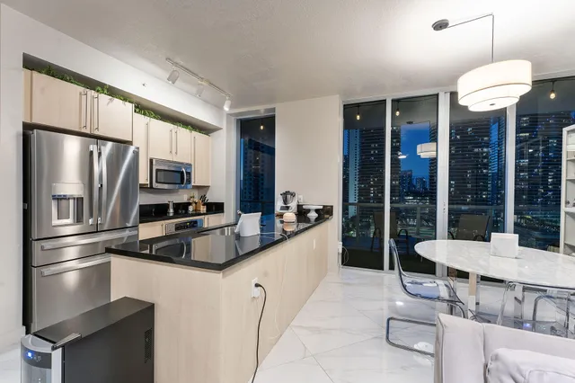 a kitchen with stainless steel appliances granite countertop a sink refrigerator and cabinets