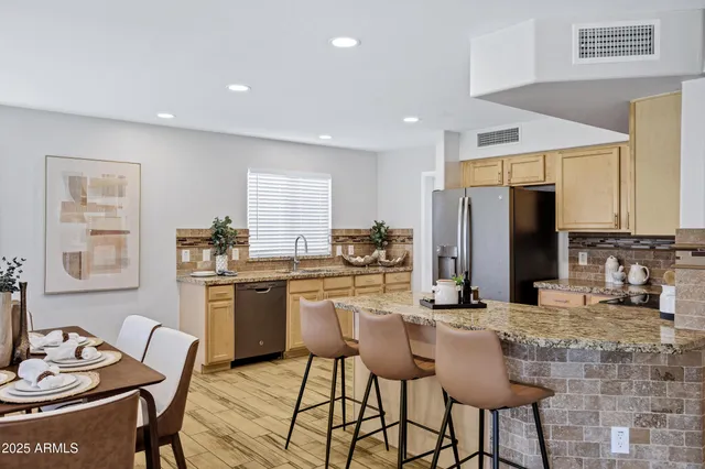 a kitchen with stainless steel appliances kitchen island granite countertop a sink and cabinets
