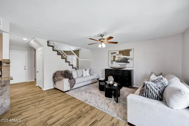 a living room with furniture kitchen view and a chandelier