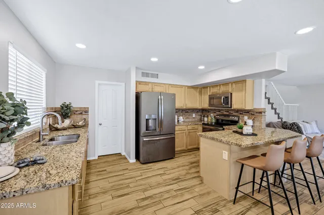 a kitchen with stainless steel appliances granite countertop a refrigerator and a sink