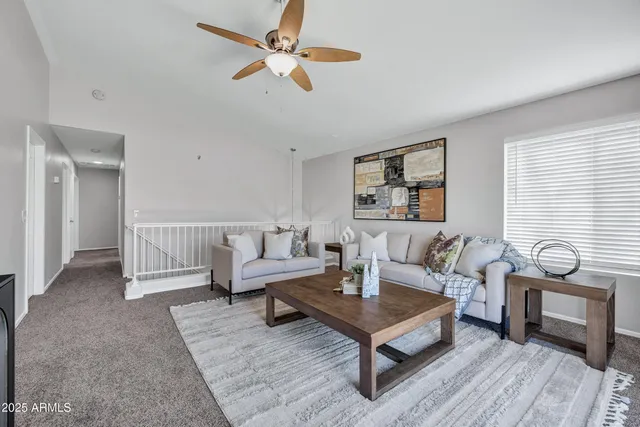 a living room with furniture a ceiling fan and a rug