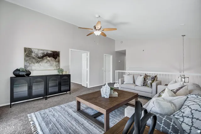 a living room with furniture a clock on wall and a window